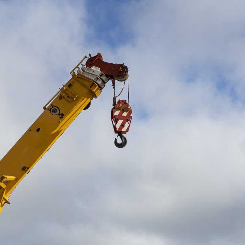 Low angle shot of a construction crane against the cloudy sky